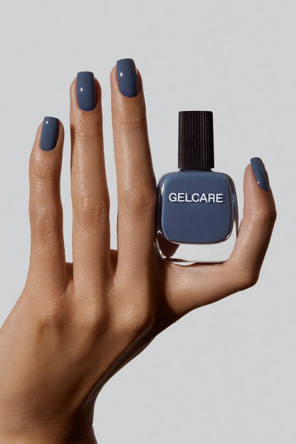 Bouteille de vernis bleu denim Gelcare dans une main