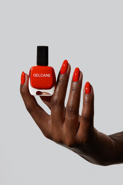 Bouteille de vernis corail Gelcare dans une main