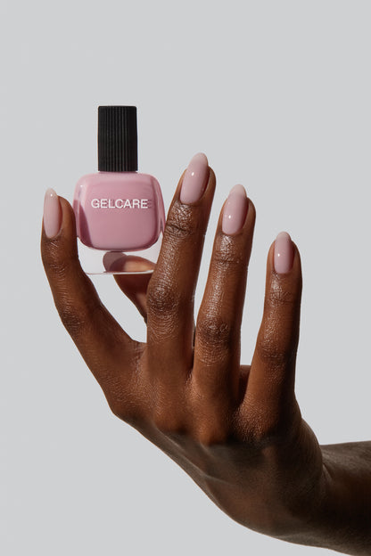 Bouteille de vernis rose bb cream Gelcare dans une main