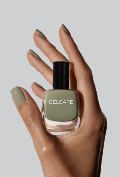 Bouteille de vernis vert sauge herbal Gelcare dans une main